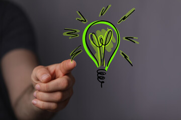 Hands holding green nature in the light bulb