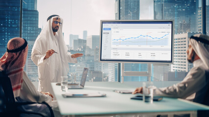 Emirati Businessman Holds Meeting Presentation for International Business Partners. Manager Uses Whiteboard with Growth Analysis, Charts, Statistics and Data. Saudi, Emirati, Arab Office Concept.