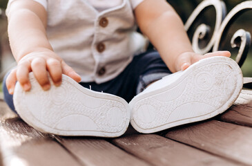 Children's shoes. Baby boy shoes sitting on a park bench