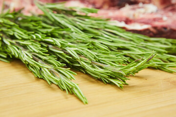 Herb spice rosemary lies on a wooden background. Seasonings for the kitchen and cooking.