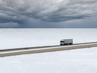 Truck driving on snowy road on a snowy winter day