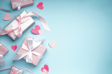 Gift boxes for Valentine's Day and confetti on blue background, space for text. Flat lay.