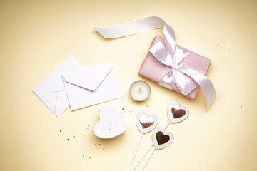 Gift boxes for Valentine's Day and confetti on yellow background, flat lay.