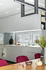 Stylish composition of elegant dining room interior design with velvet chairs, design wooden table, lamps, chimney and beautiful personal accessories. Modern home decor. Template.