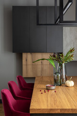 Stylish composition of elegant dining room interior design with velvet chairs, design wooden table,...