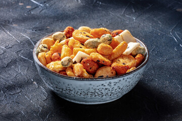 Japanese rice crackers in a bowl on a black slate background