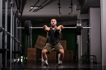 Obraz na płótnie Canvas Muscular athlete lifting very heavy barbell