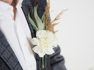 Boutonniere with white carnation and dried foliage
