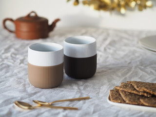 Two mugs (Royal Copenhagen), tea pot, golden teaspoons and crackers