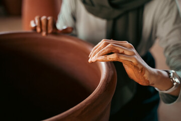 Close up of a woman's hand making clay pot