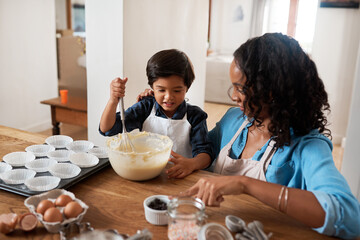Baking is a win-win activity. Shot of a woman baking at home with her young son.