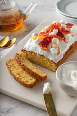 orange sponge cake garnished with fresh bloody oranges and cream. Vertical