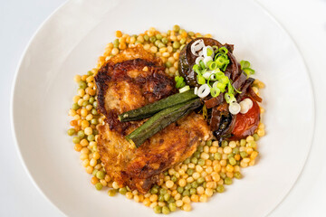 Breaded fried celery, okra, eggplant, zuchini and onion on couscous, closeup.