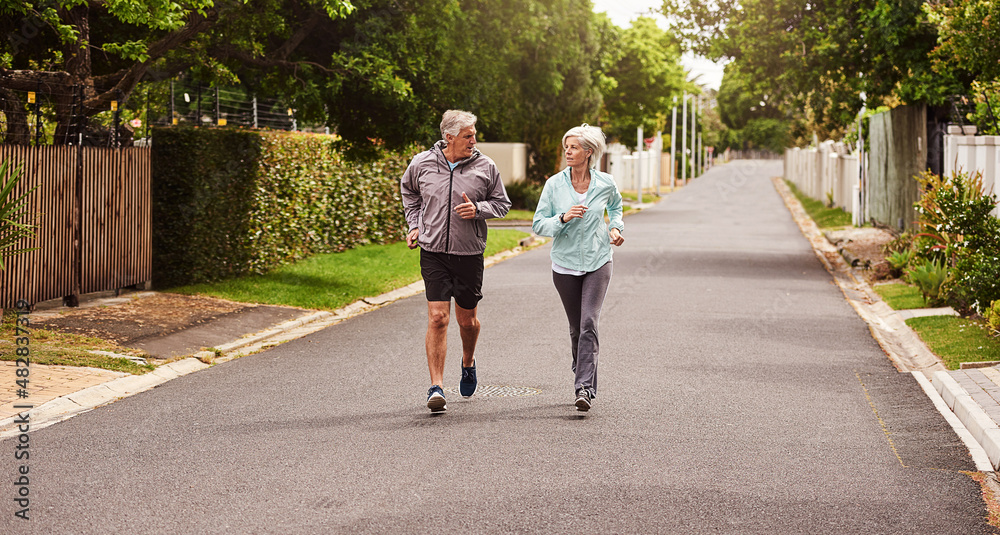 Aufkleber try and keep up. shot of a cheerful senior couple having a jog together outside in a suburb.