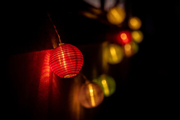 Orange balls, glowing fairy lights, Japanese lanterns isolated on black