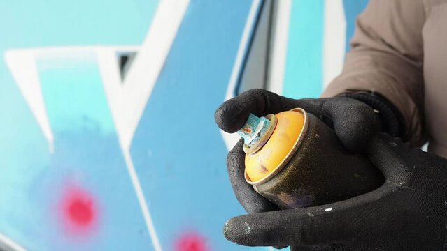 the artist puts the cap on the aerosol can of paint