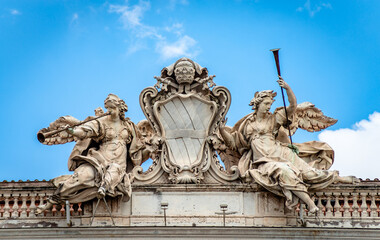 Two trumpeting angels representing Fame, the Corsini family Coat of Arms on Palazzo della Consulta on Quirinale Hill, Rome. Built in 1735, it houses the Constitutional Court of the Italian Republic.