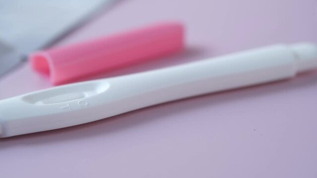 Pregnancy test kit on light purple background 