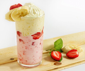 Strawberry-banana milkshake in a glass tumbler garnished with mint leaves, strawberries, banana slices and whipped cream. Healthy breakfast or snack, cafe poster