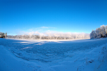 Winter scene with a lake and ice steam