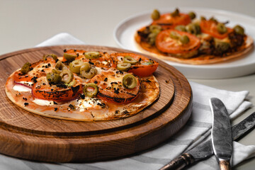 Wheat tortilla with tomatoes, mozzarella cheese and olives. Close-up