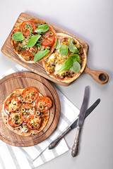 Homemade wheat tortilla with tomatoes, mozzarella cheese, olives and fresh spinach. Vertical shot