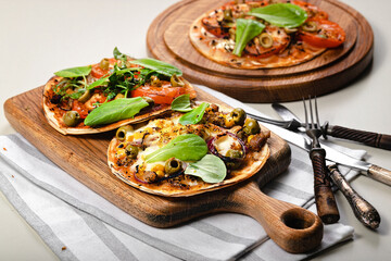 Homemade wheat tortilla with tomatoes, mozzarella cheese, olives and fresh spinach.