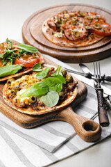 Homemade wheat tortilla with tomatoes, mozzarella cheese, olives and fresh spinach. Vertical shot