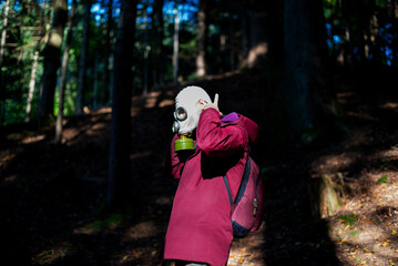 Ecological catastrophy. Post apocalyptic survivor in gas mask. Man at forest.