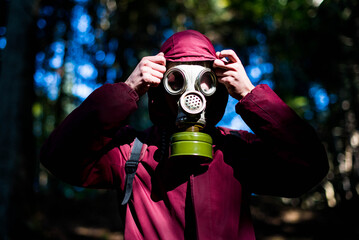 Ecological catastrophy. Post apocalyptic survivor in gas mask. Man at forest.