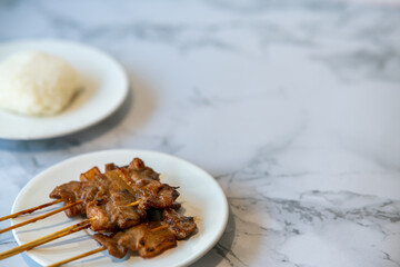 grilled pork with sticky rice on a white marble plate leave space