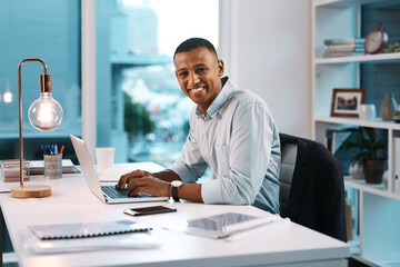 Success is a mentality. Portrait of a handsome young businessman working on his laptop during a...