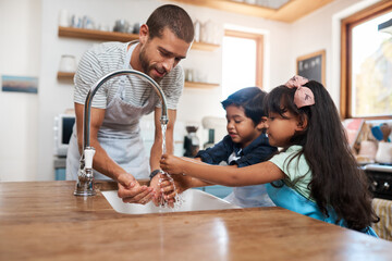 Let's wash those germs away. Cropped shot of a man and his two children washing their hands in the kitchen basin. - obrazy, fototapety, plakaty