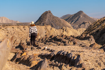 A young hiker girl visiting the landscapes of Colas de Dragon in the desert of Tabernas, Almería...