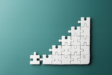 white puzzle jigsaw in graph shape on green background , business concept