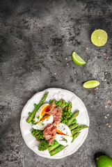 Ketogenic diet meal Poached egg with asparagus spears and prosciutto. banner, menu recipe place for text, top view