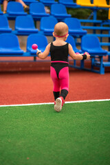 Obraz premium girl child in sportswear on the sports ground