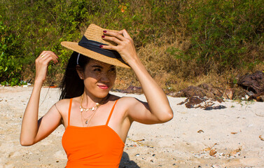 Portrait of woman on the beach with a hat