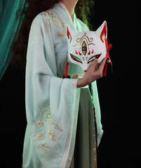 Woman wearing kimono, hanfu and a fox mask. Japanese, chinese traditional concept. Kitsune