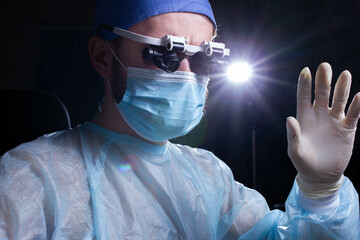 Doctor in surgical glasses for neurosurgery in the operating room. The concept of microsurgery