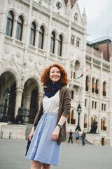 Obraz premium Young redhead Caucasian woman near Parliament Building, Budapest, Hungary