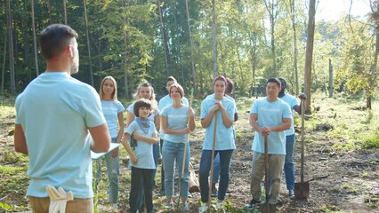 Group of volunteers concerned about problem of environmental pollution. Leader of activists giving advises about collecting waste. Ecology, biosphere protection concept