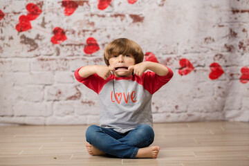 Fototapeta na wymiar Boy small child posing for kisses for valentines day charging cute kid making faces being sweet. 