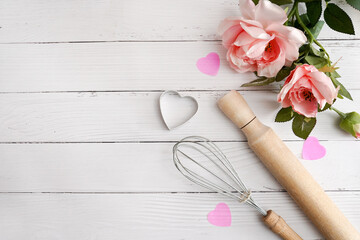 Valentine day baking background. Ingredients for cooking Valentine's hearts on white wood with pink...