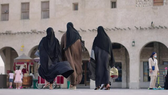 Muslim woman walking on the street with tradicional dress at Doha
