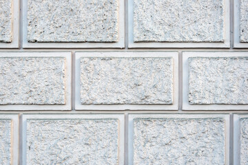 Fototapeta premium Imitation of a wall made of gray rough stone. Masonry of blocks. Decorative plaster. For background or texture