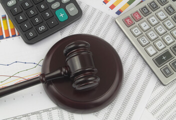 Judge gavel and two calculators on financial documents. Arbitration concept.	