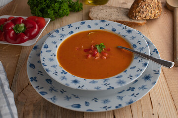 Traditional red bell pepper soup on rustic deep plate 