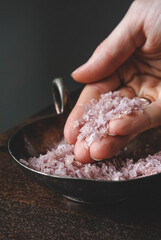 Flakes of pink wine salt in a woman's hands
