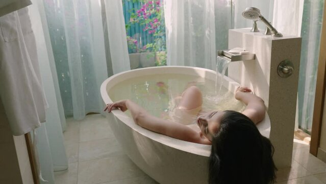 relaxed woman touching skin in bath. Sexy girl taking bathtub at home. Romantic woman relaxing bath in slow motion.

